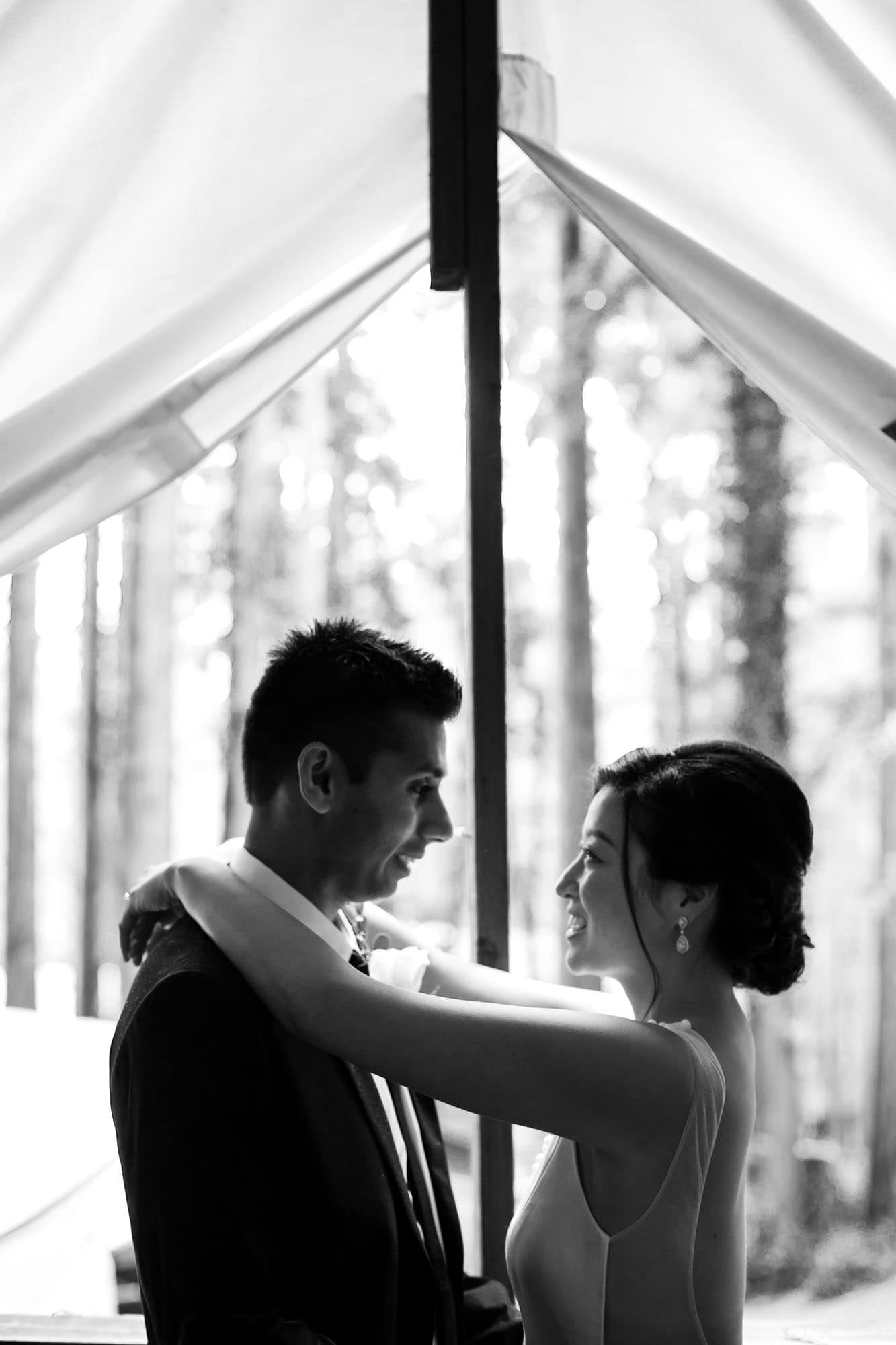 Wedding couple in a tent looking into each others eyes