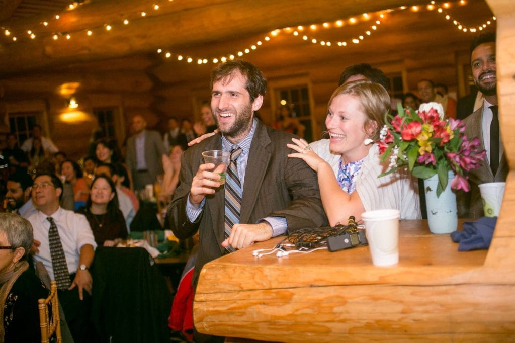 Guests at a wedding reception in a lodge laughing