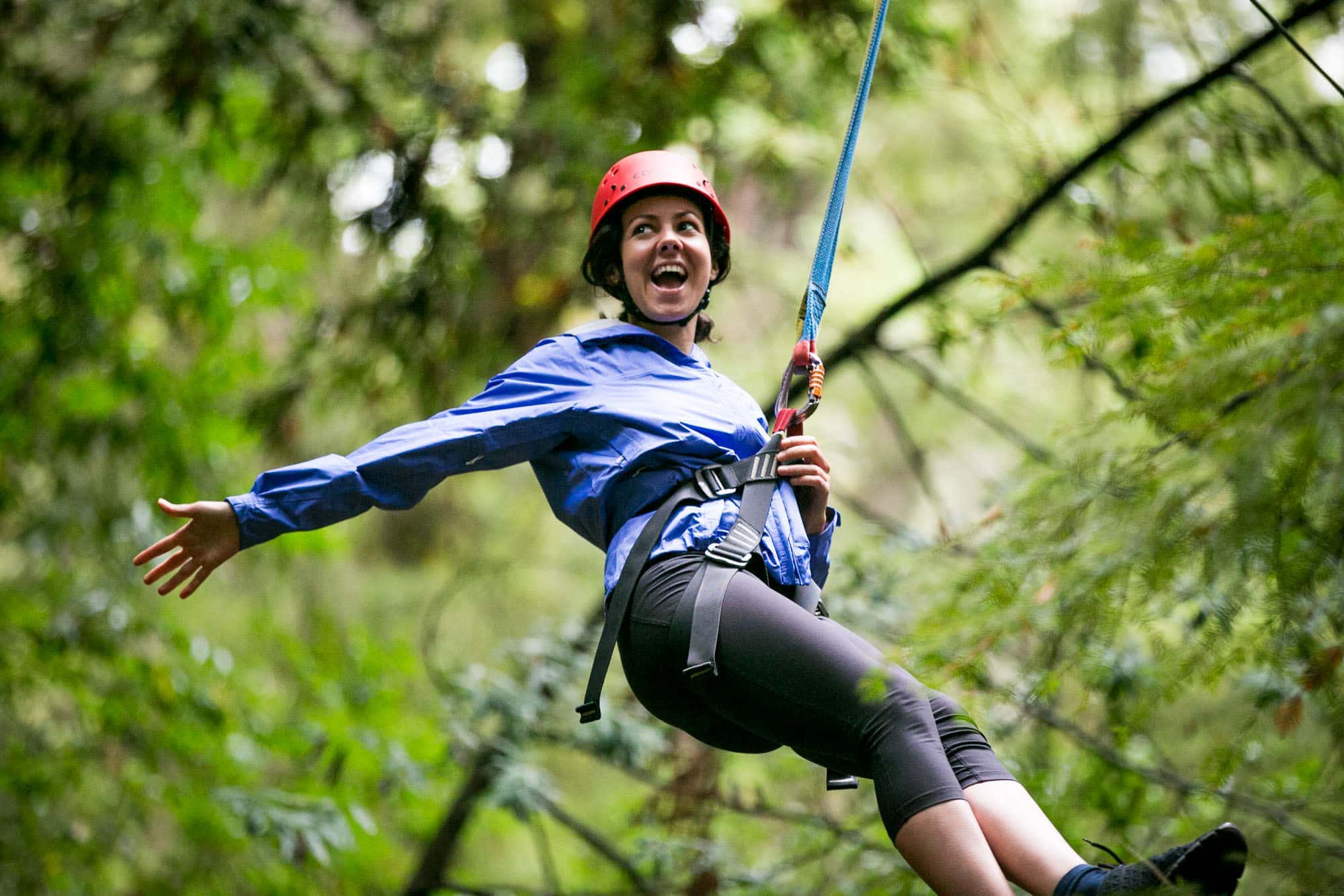woman smiling and ziplining at the YMCA camp Campbell