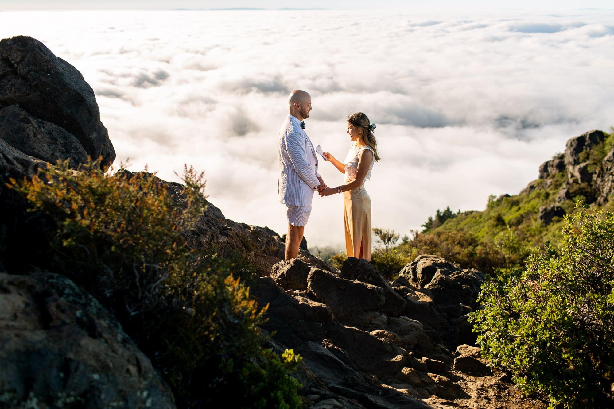 Bride reading her vows to her groom on top of Mt. Tamalpais above the clouds