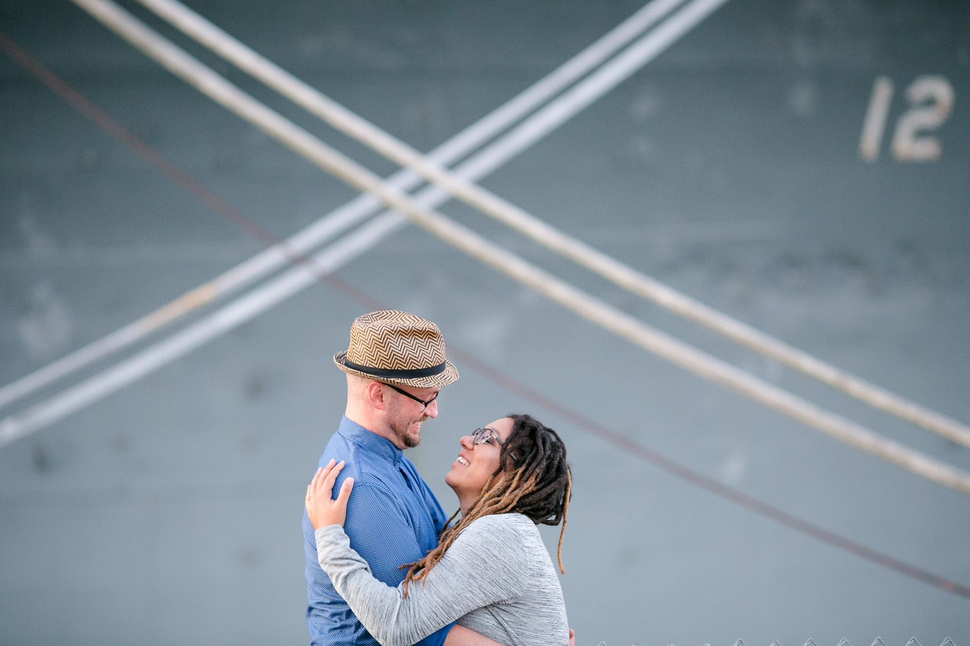 Couple hugging in front of crossed ropes on ship