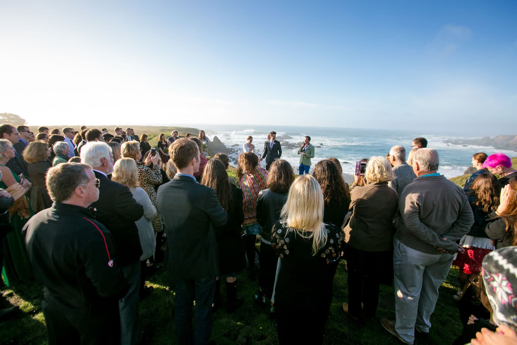 wide shot of full wedding ceremony on a bluff overlooking the ocean