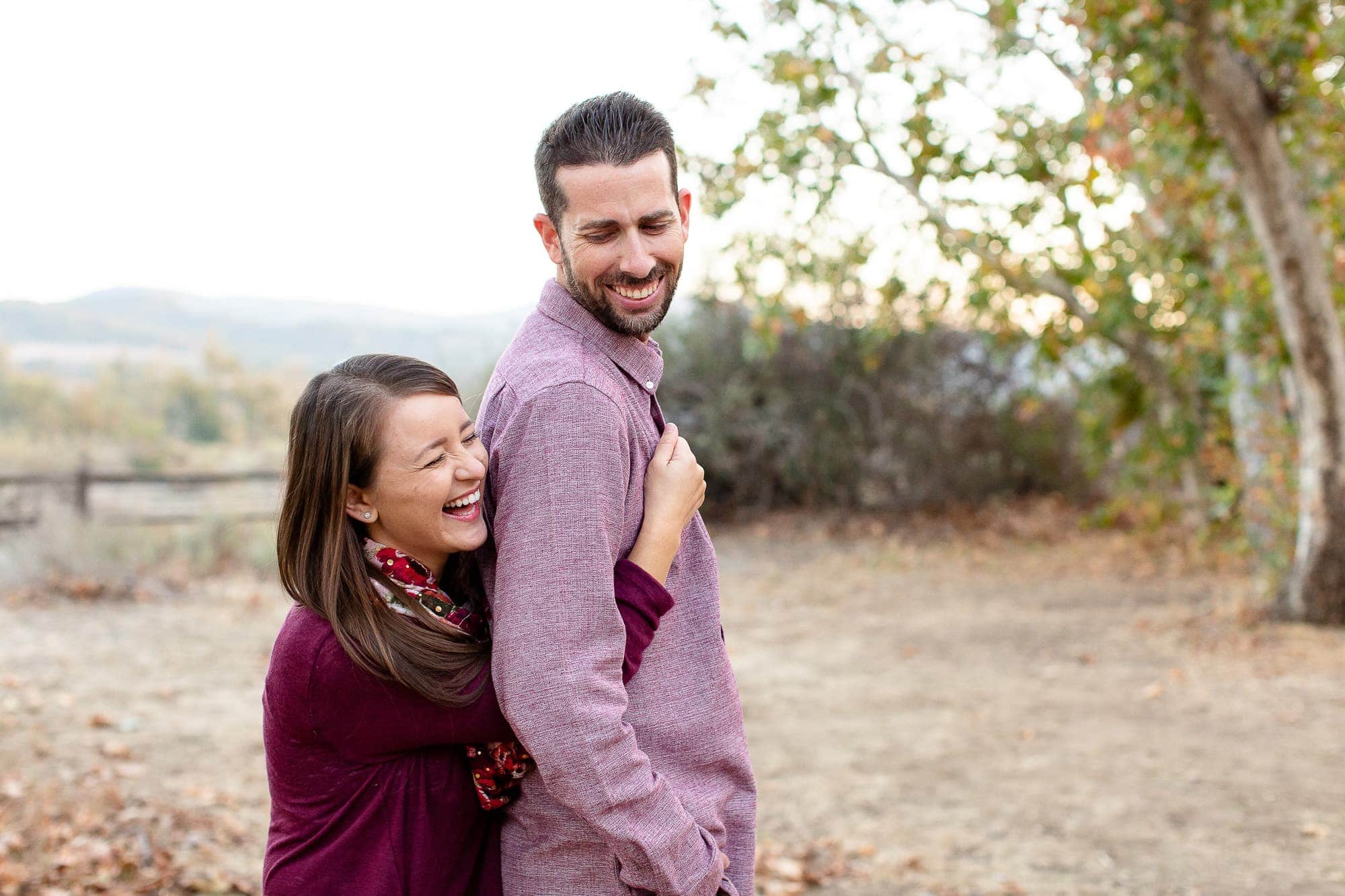 Couple embracing and laughing in front of desert landscape