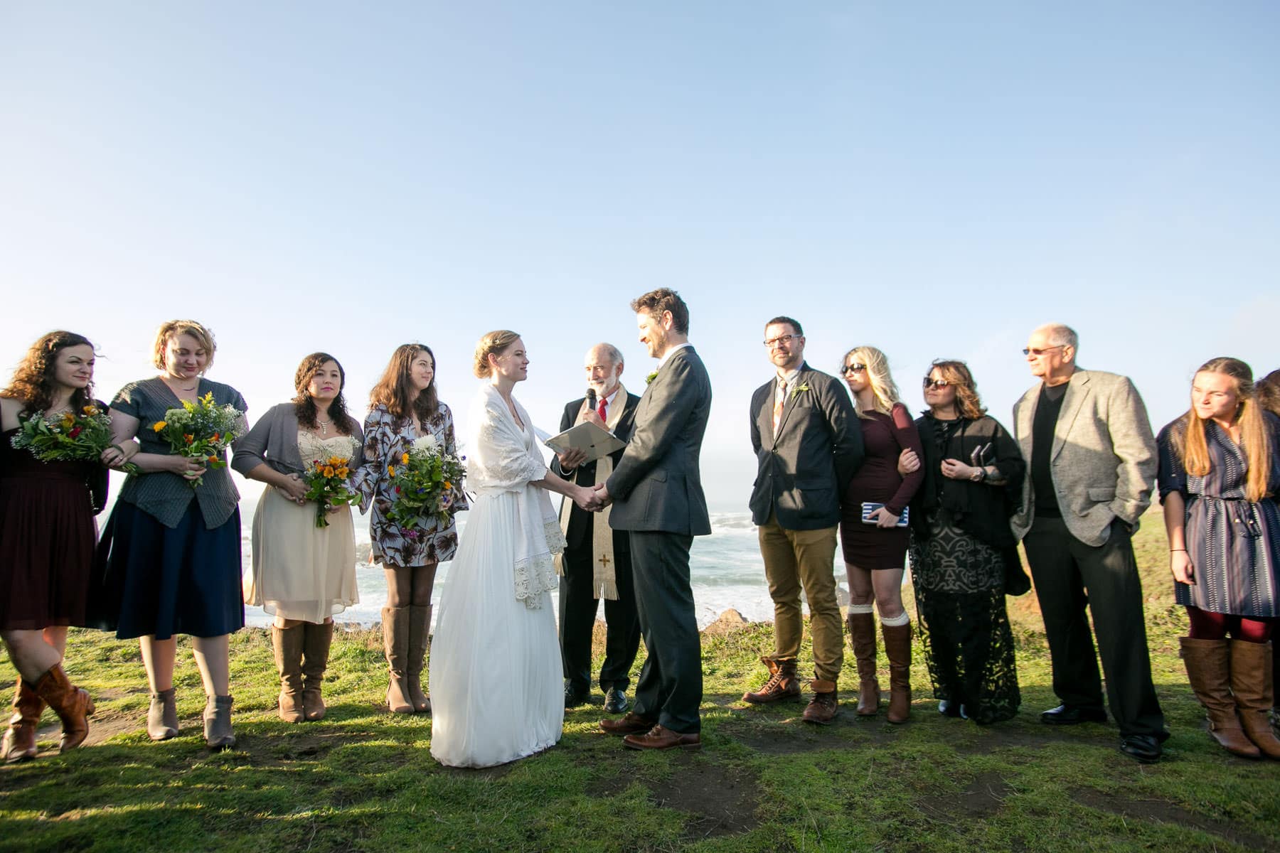 Bride and Groom surrounded by friends and family during ceremony outside