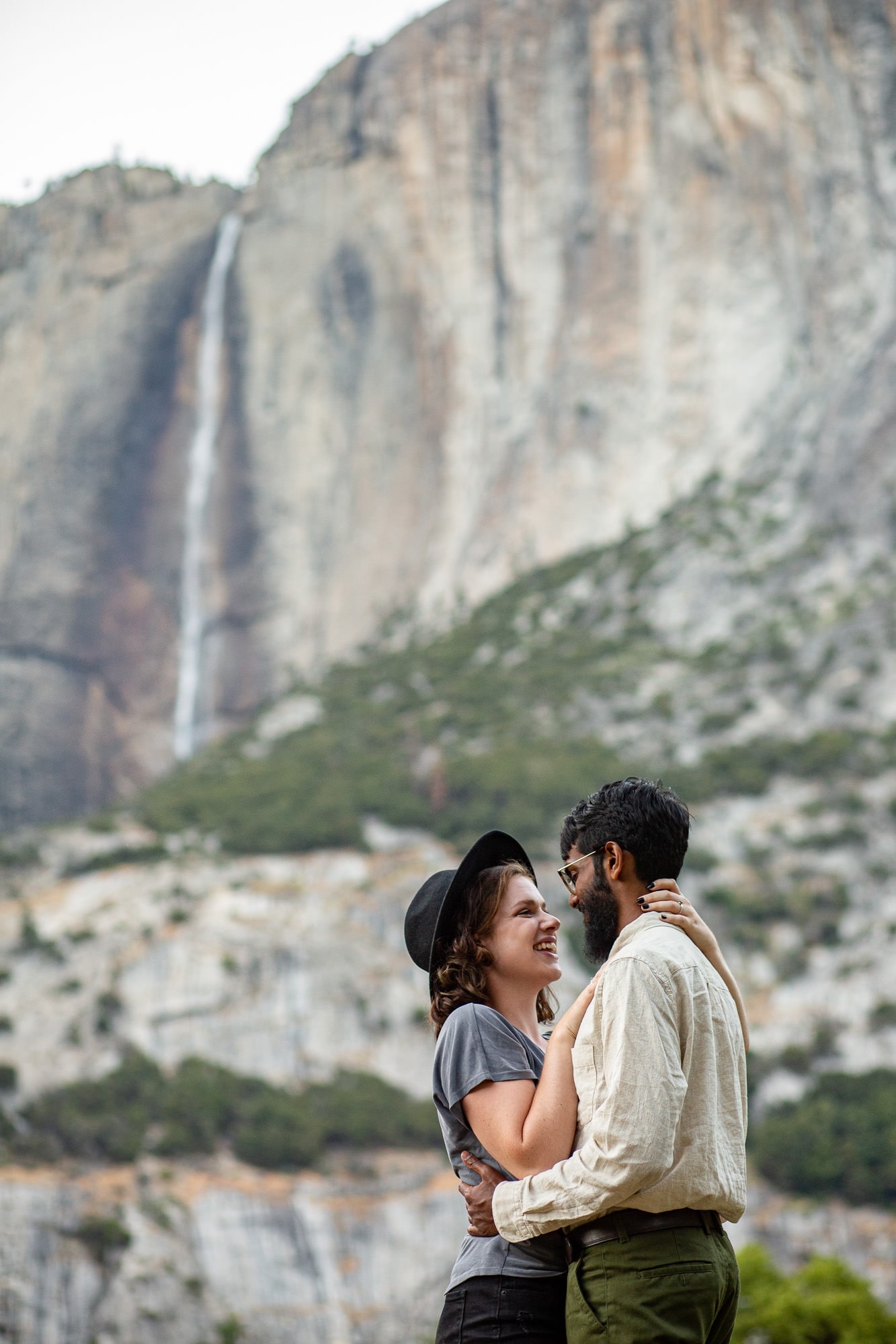 Couple embracing with mountain and waterfall behind