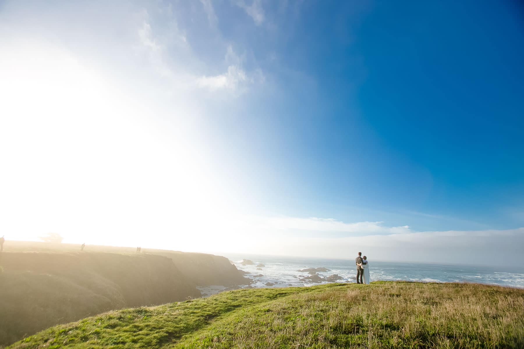Grassy Bluff overlooking the ocean with a couple embracing on the edge