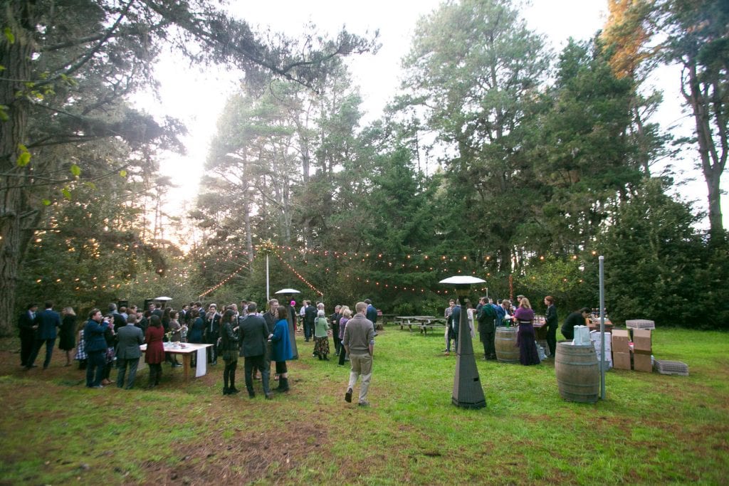 Group of people talking in the woods at a wedding reception