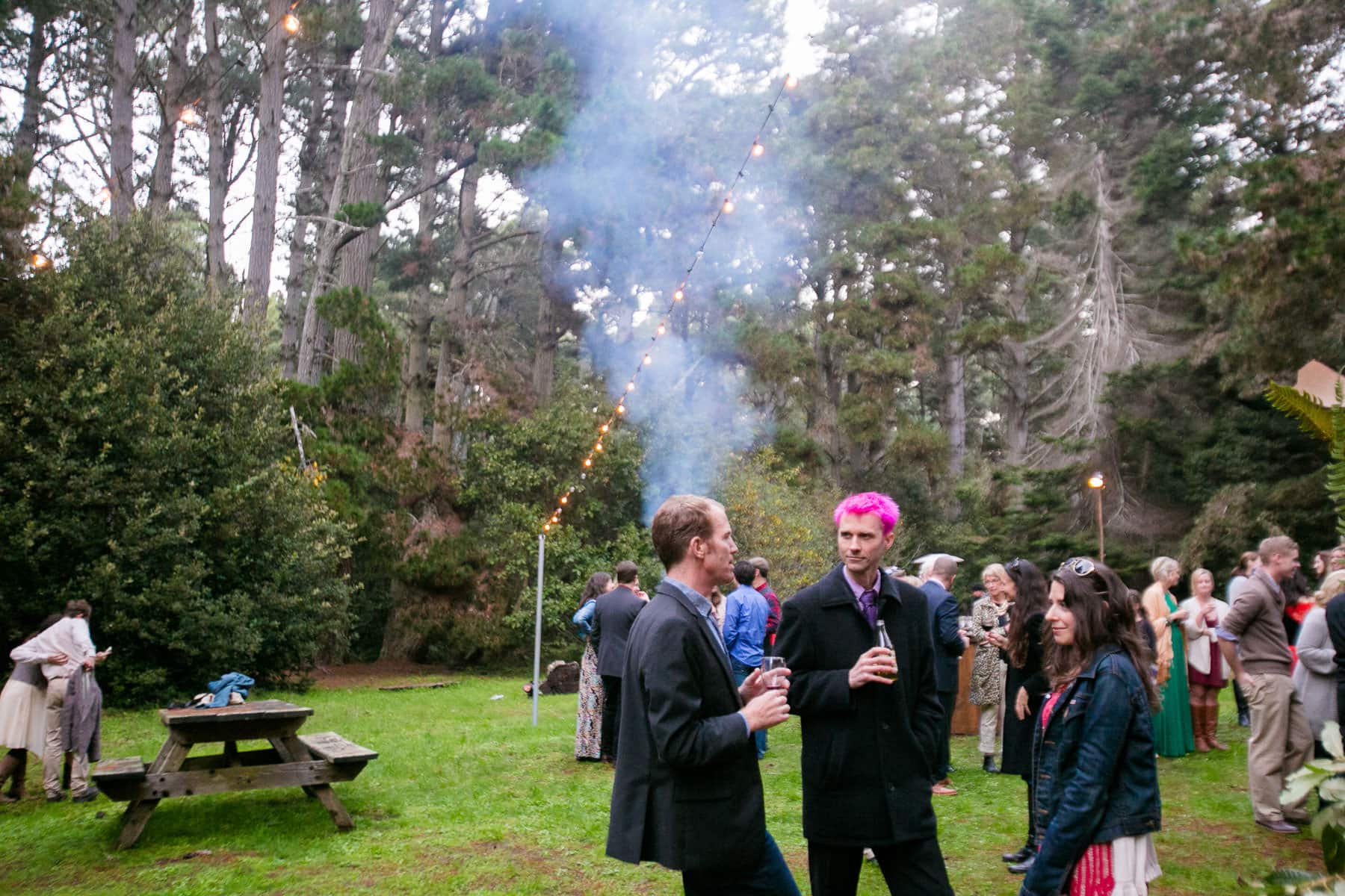 Group of people talking in the woods at a wedding reception