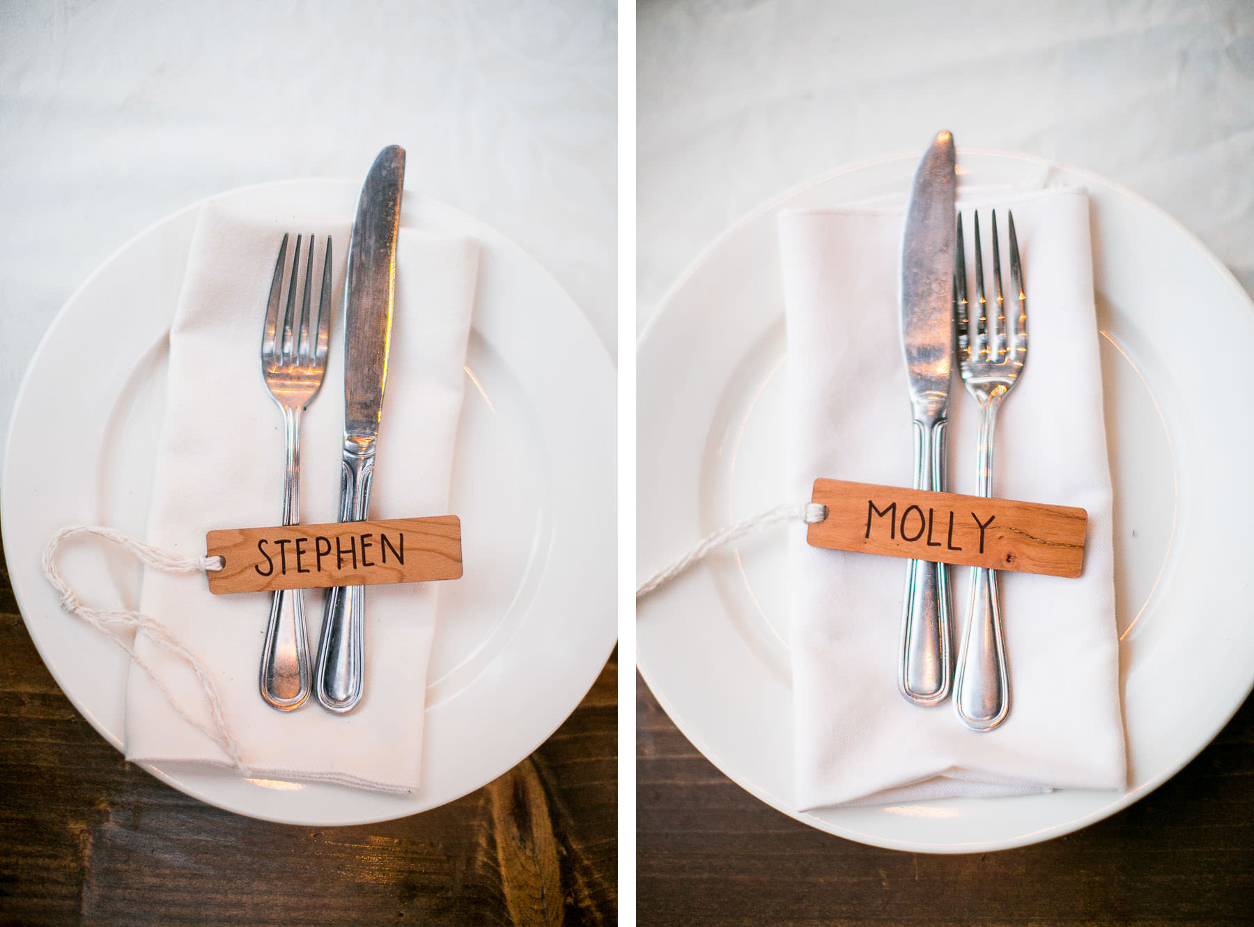 Two plates with silverware and nametags on a wooden table