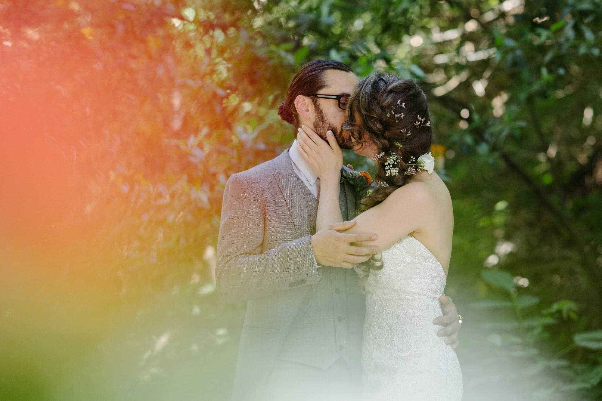 Modern Groom and bride kissing outdoors after first look