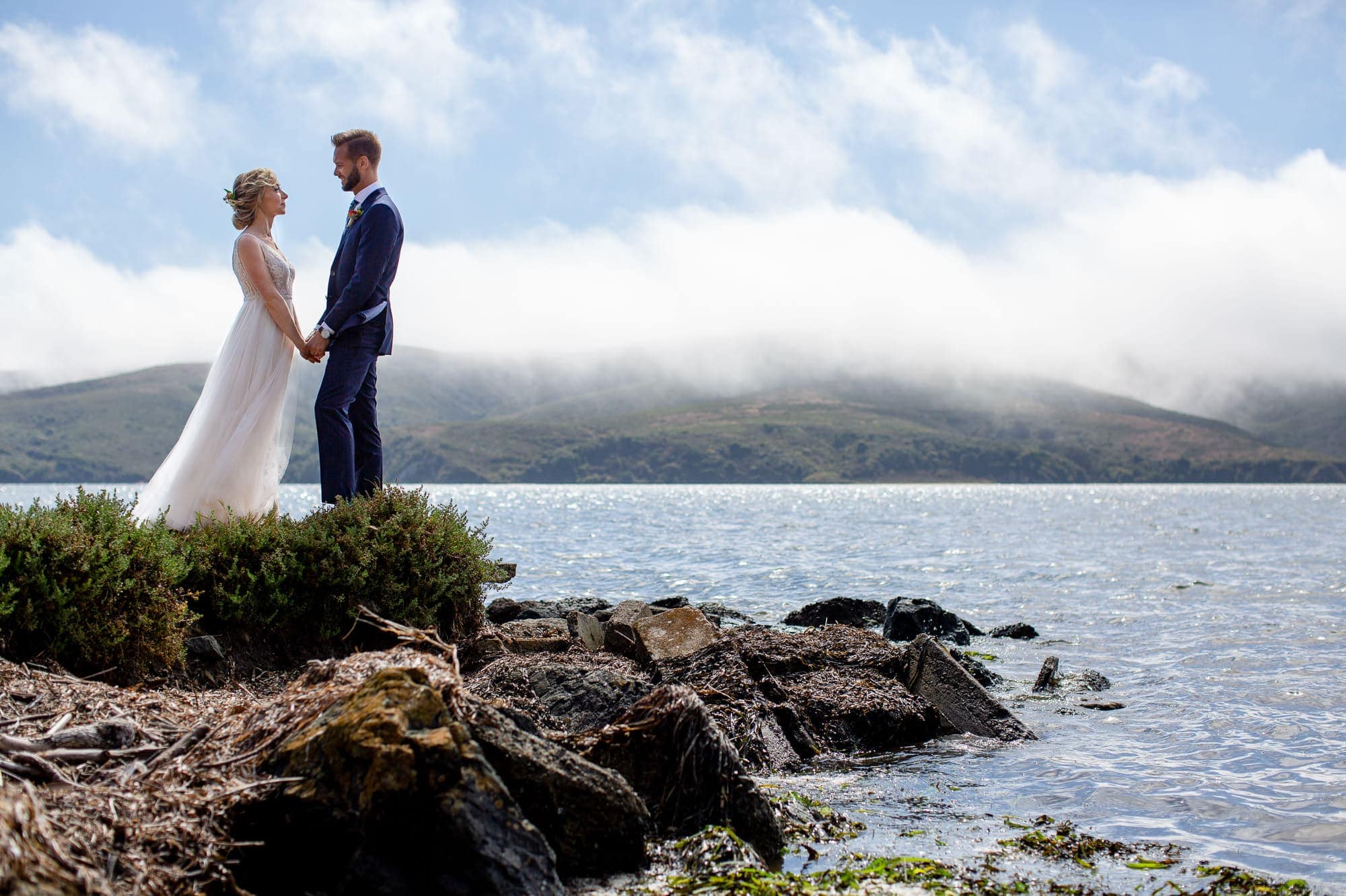 Sunny wedding photos with bride and groom overlooking Tomales bay