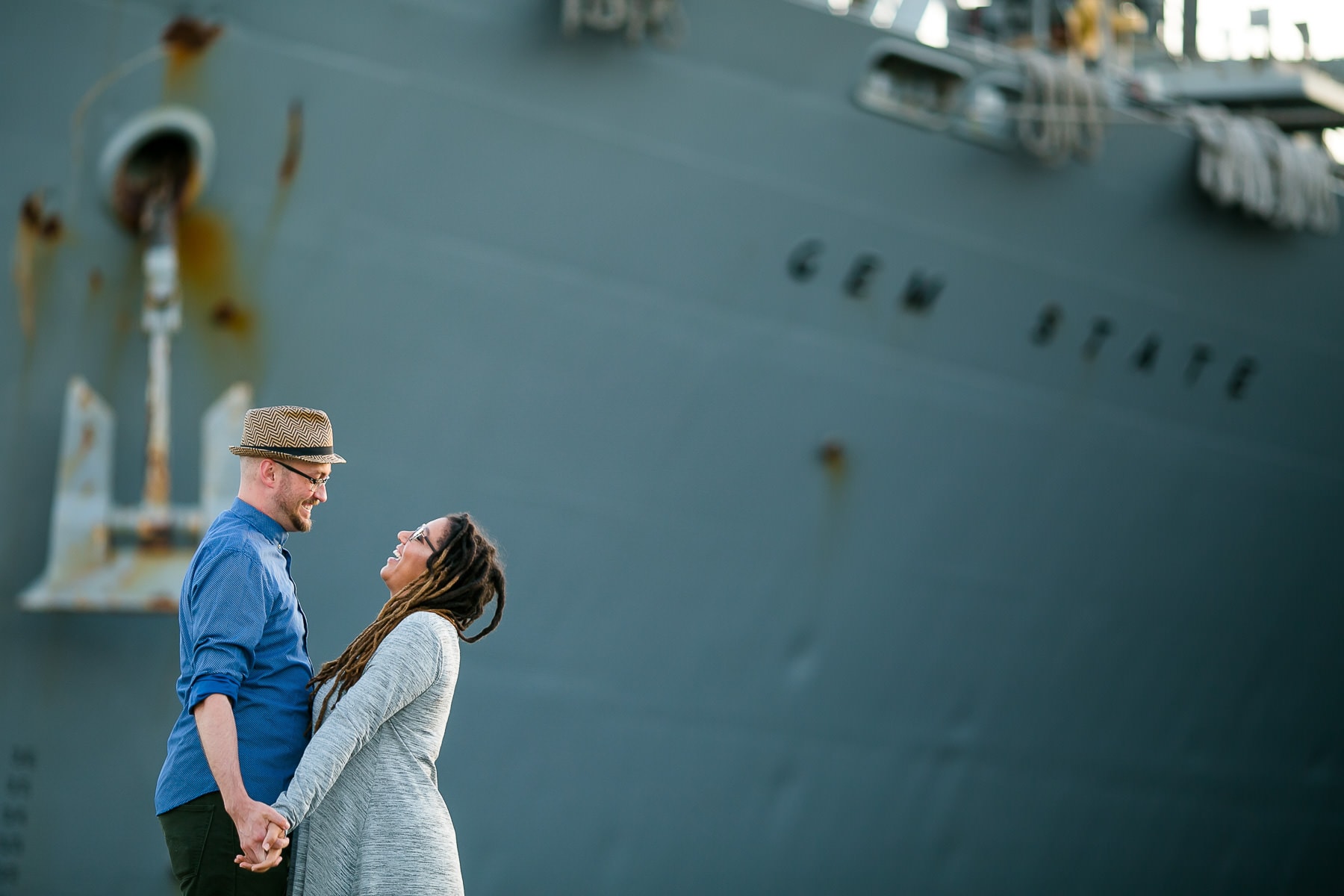 Couple looking at each other in front of a Navy Ship