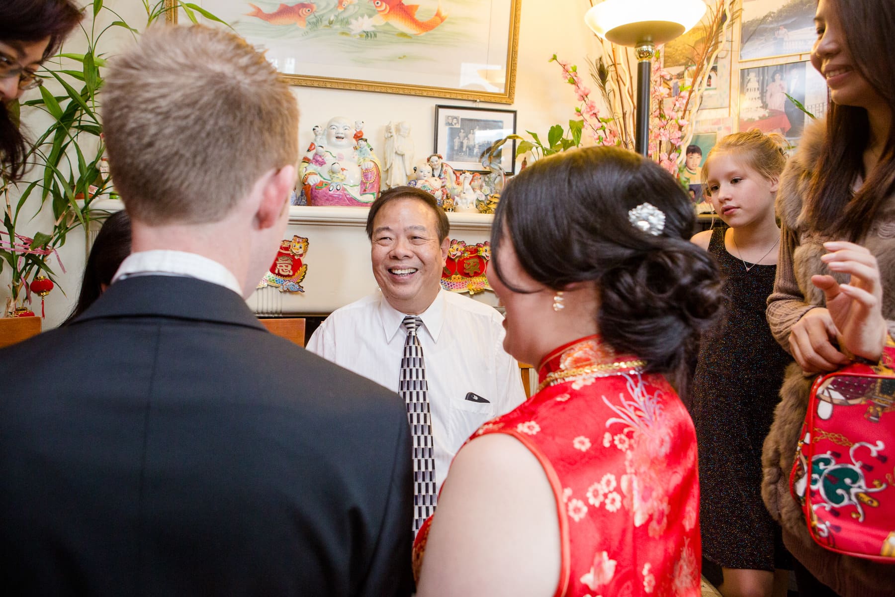 Man in between bride and groom smiling during tea ceremony