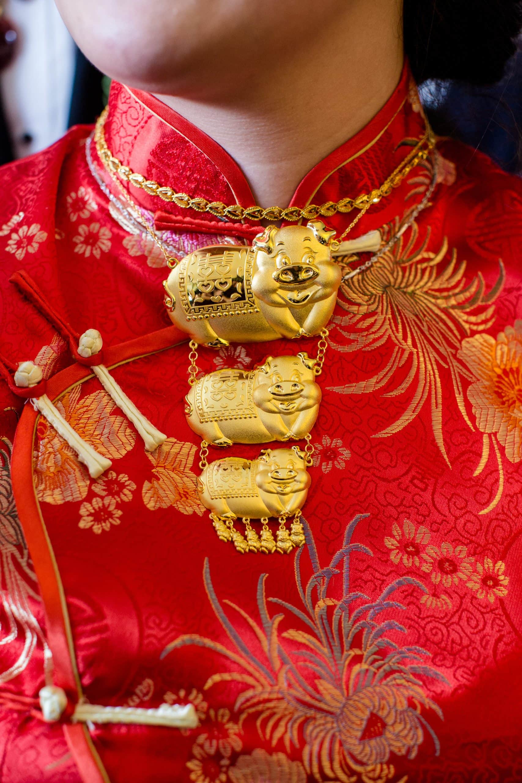 Detail of a gold pig necklace gift from tea ceremony