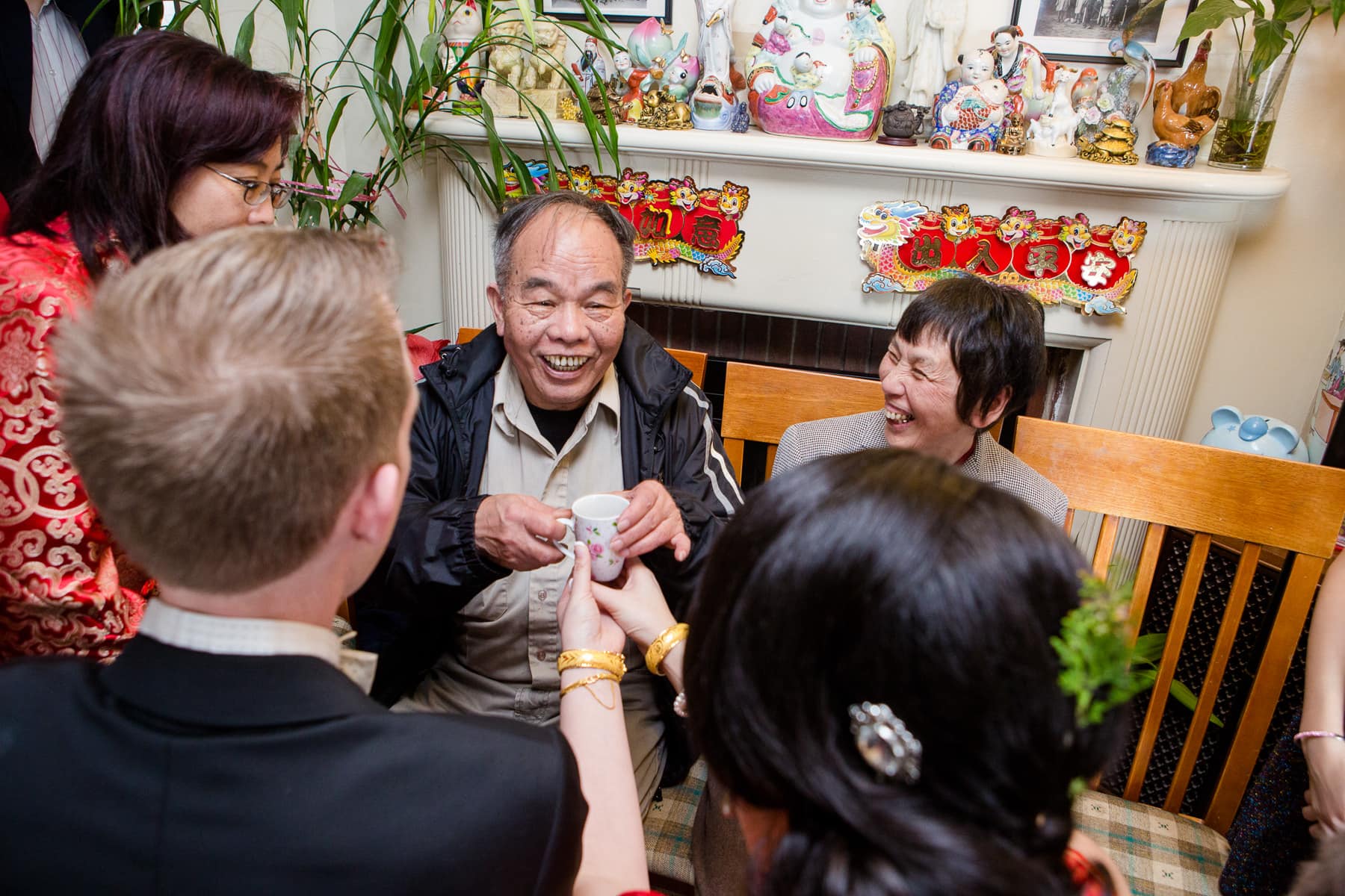 Bride and groom presenting family with tea during chinese tea ceremony