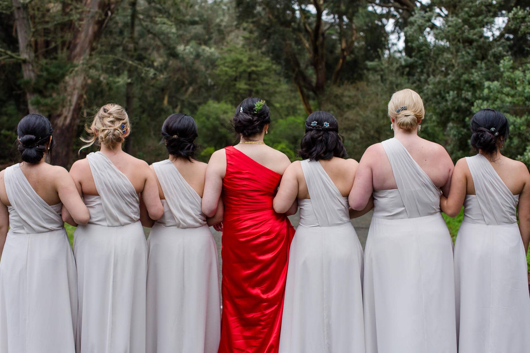 Bridesmaids lined up facing away showing details of hair and dresses