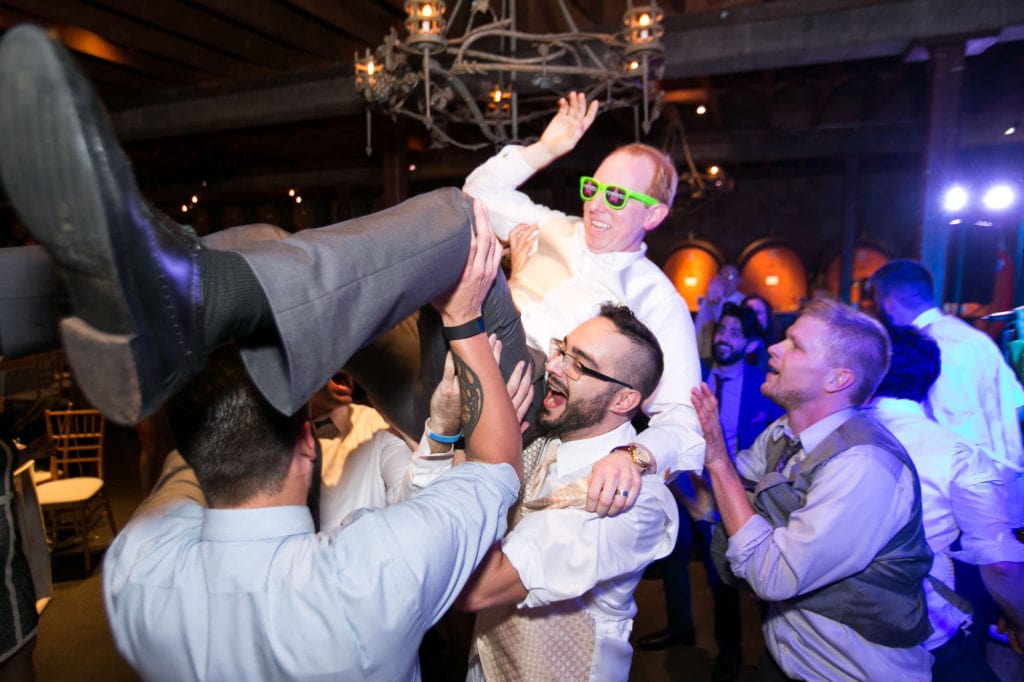 Guests picking up groom at reception on dance floor